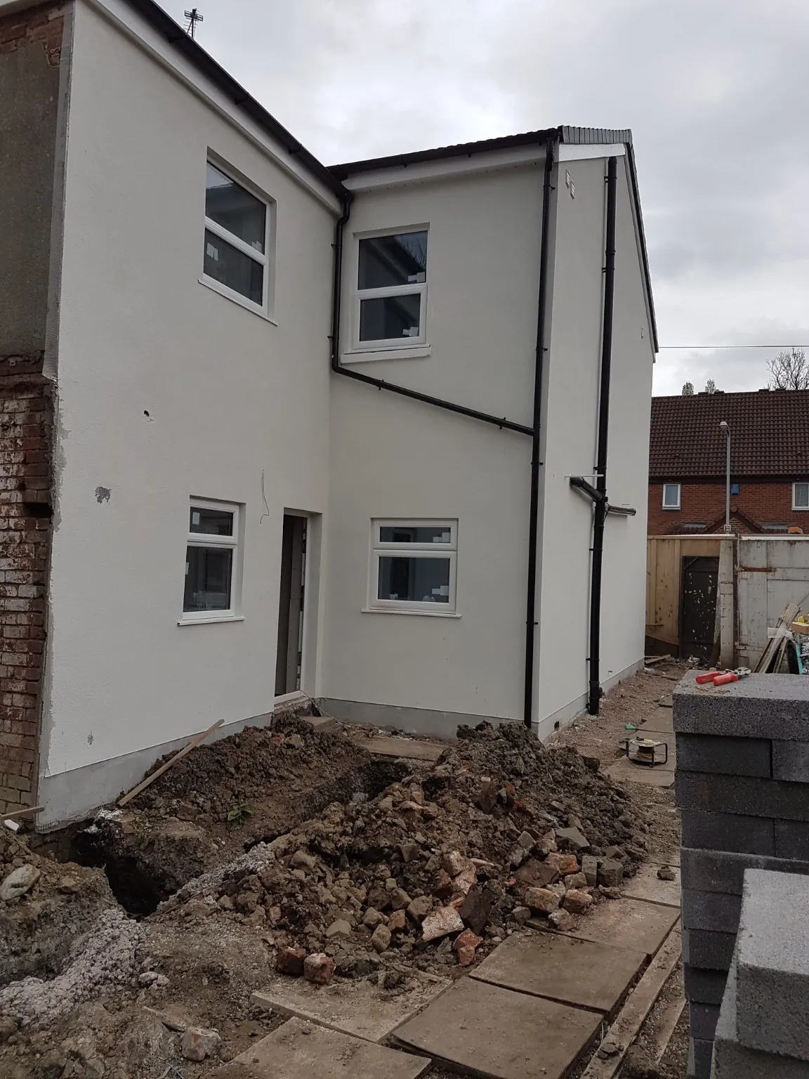 Newly rendered walls, fitted windows and rainwater goods